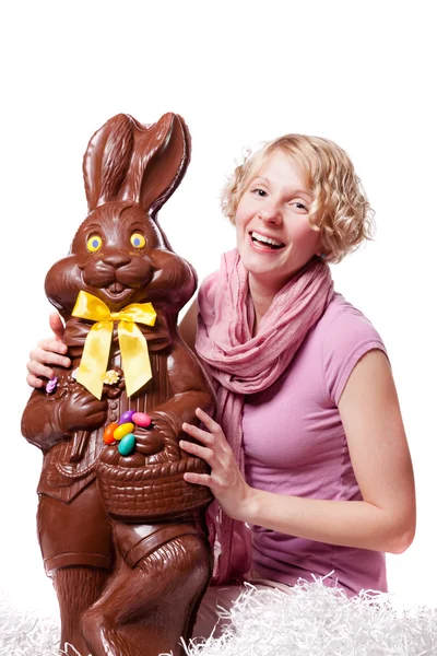 Ragazza che ride e tiene un enorme coniglietto di Pasqua al cioccolato — Foto Stock