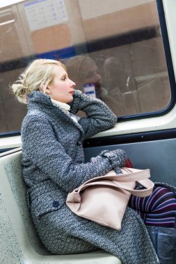 bir metro vagonu içinde oturan genç kadın