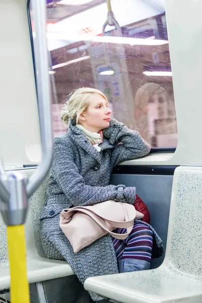 Mujer joven sentada dentro de un vagón de metro — Foto de Stock