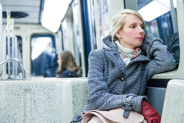 Jovem mulher sentada dentro de um vagão de metrô — Fotografia de Stock