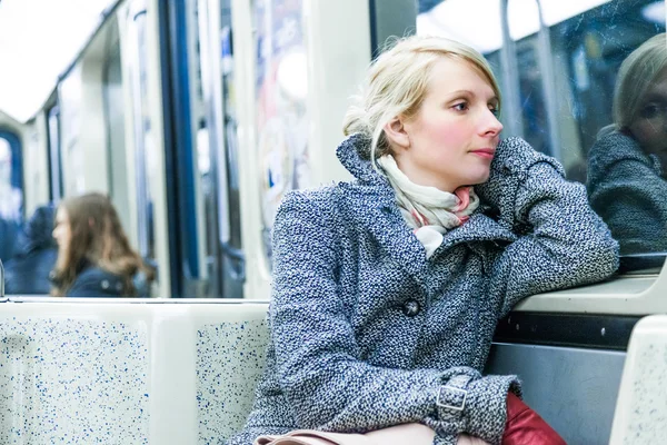 Jovem mulher sentada dentro de um vagão de metrô — Fotografia de Stock