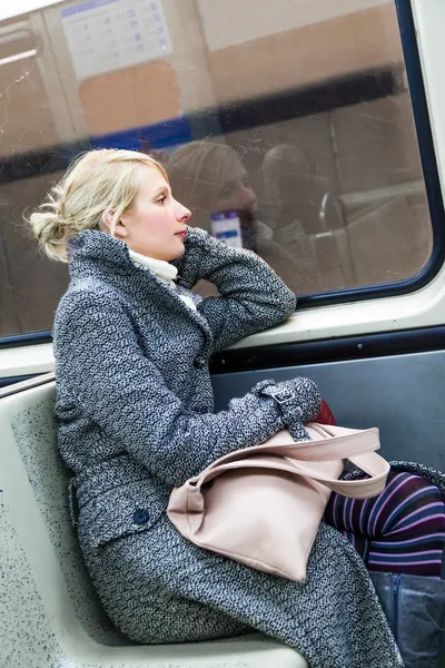 Mladá žena sedící uvnitř vagónu metra — Stock fotografie