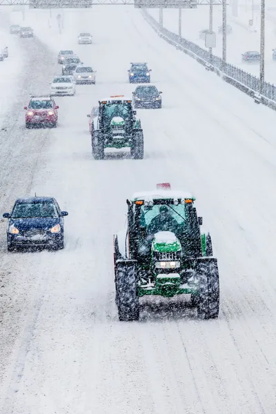 Dos quitanieves y coches durante una tormenta de nieve —  Fotos de Stock