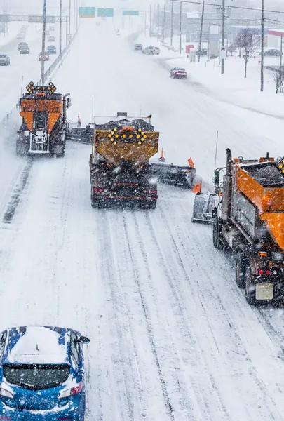 Arados de nieve alineados en árboles despejando la carretera —  Fotos de Stock