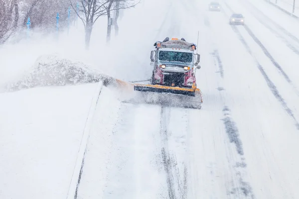 Sneeuwschuiver verwijderen van de sneeuw van de snelweg tijdens een sneeuwstorm — Stockfoto