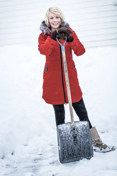 Femme heureuse avec une pelle dans un parking — Photo