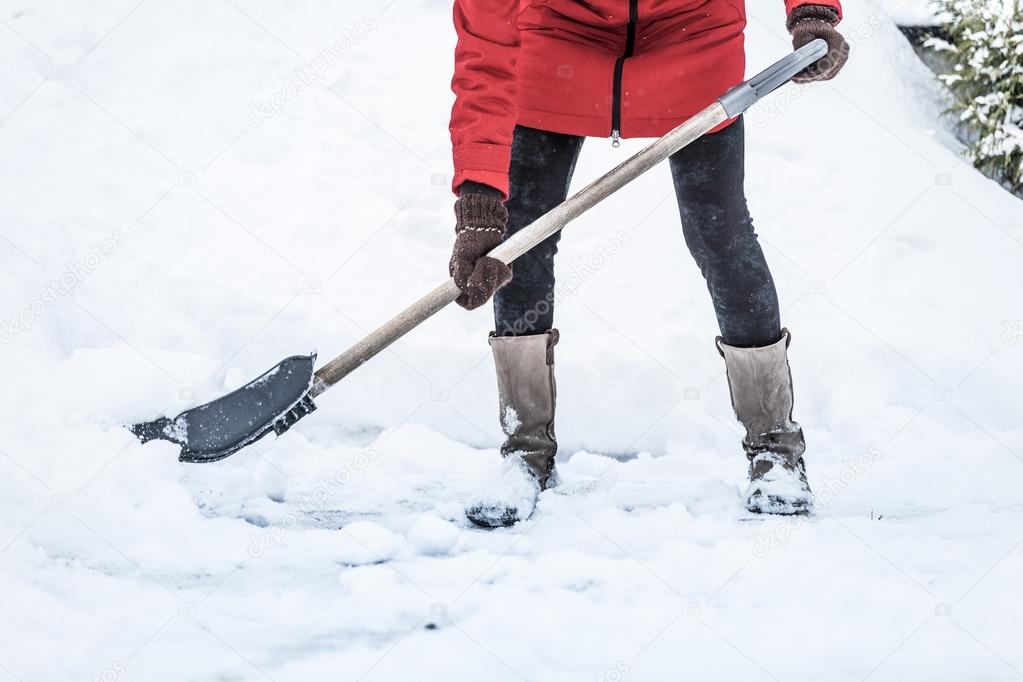 Close-up of Woman Shoveling her Parking lot