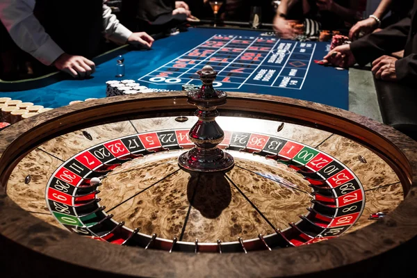 Detalles de la ruleta brillante de madera en un casino y la gente — Foto de Stock