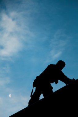 müteahhit siluet bir çatının üstünde çalışma içinde