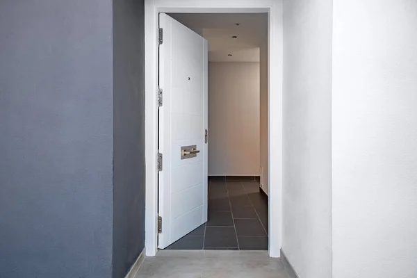 Open white door to the corridor of the house
