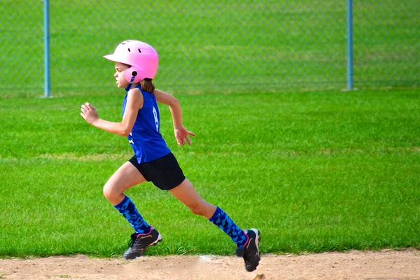 Młoda dziewczyna działa baz w softball Obrazy Stockowe bez tantiem