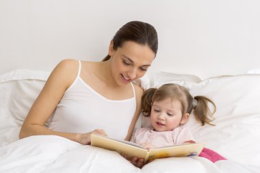 Çocuk annesiyle birlikte kitap okuma