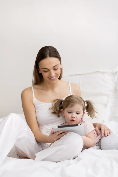 Child using tablet with her mother — Stock Photo, Image