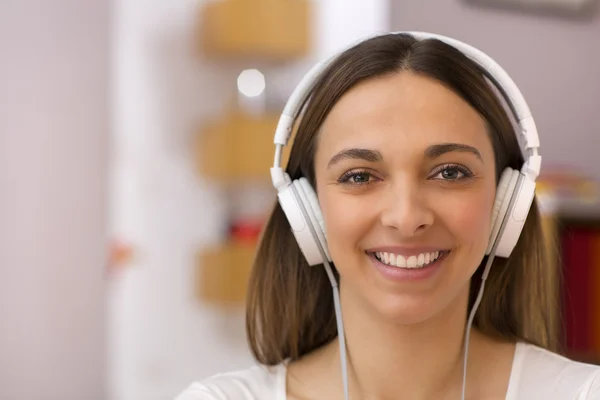 Porträtt av en kvinna som lyssnar på musik i hemmet — Stockfoto