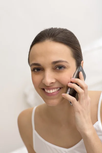 Žena telefonování v bílé ložnici — Stock fotografie