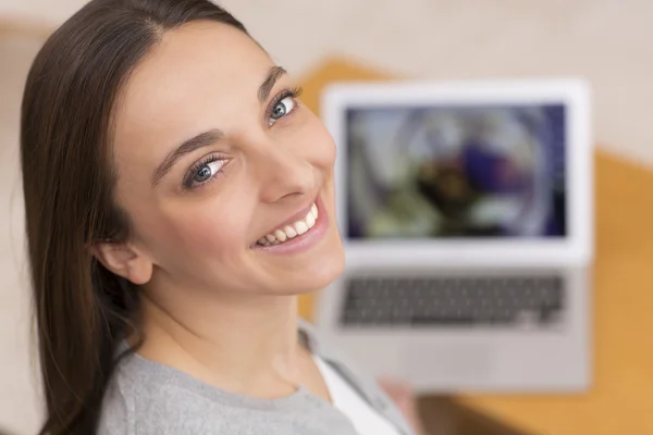 Kvinna på soffan med sin bärbara dator — Stockfoto