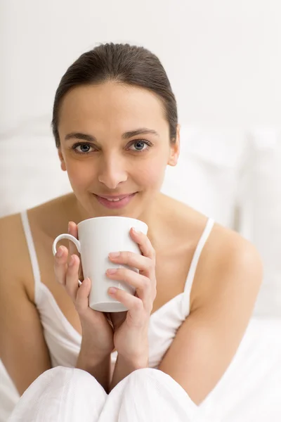 Женщина в постели пьет чай — стоковое фото