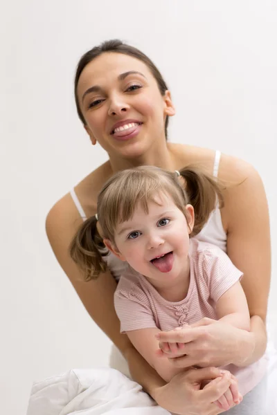 Mother and her daughter having fun and showing tongue — Stock Photo, Image