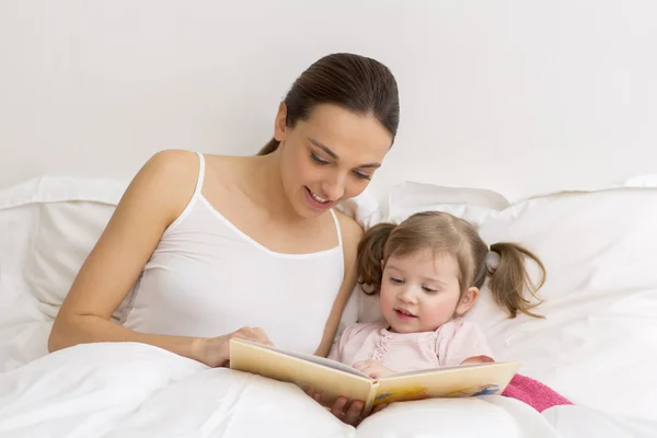 Child reading a book with her mother — Stock Photo, Image