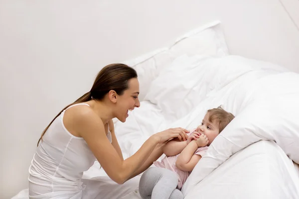 Mother and daughter playing on the bed — Stock Photo, Image