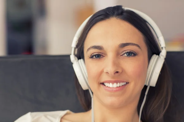 Avslappnad kvinna lyssna på musik i soffan hemma — Stockfoto