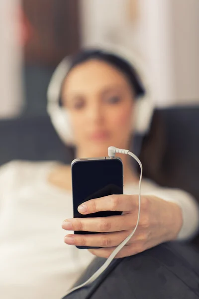 Entspannte Frau hört zu Hause im Wohnzimmer Musik — Stockfoto