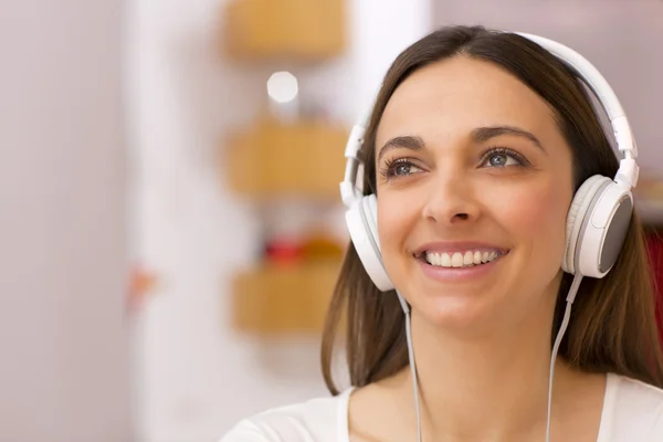 Jonge vrouw die thuis naar muziek luistert — Stockfoto