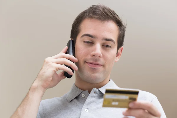Homem pagando com cartão de crédito no telefone — Fotografia de Stock