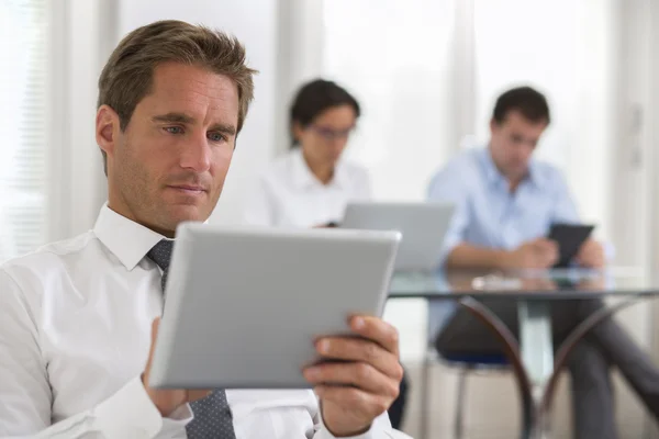 Бизнесмен пользуется планшетом в офисе — стоковое фото