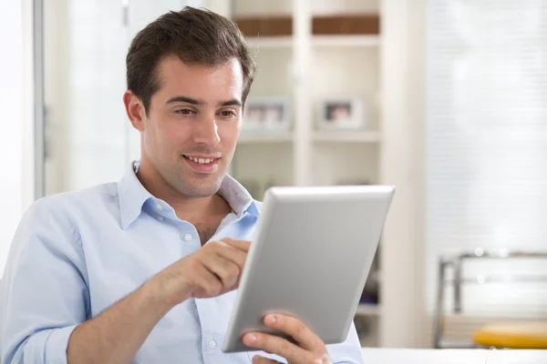 Man using tablet pc on couch at home — Stock Photo, Image