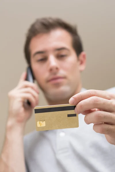 Mann bezahlt mit Kreditkarte am Telefon — Stockfoto