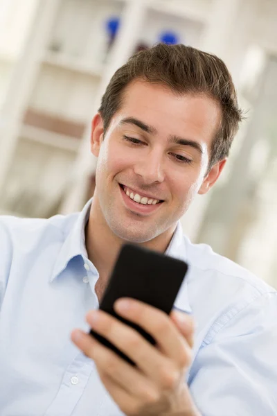 Young handsome man writting SMS on mobile phone. Stock Image