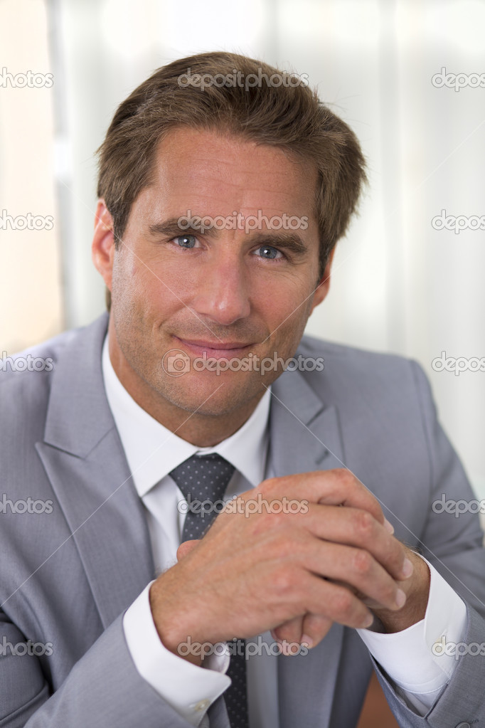 Portrait of a successful businessman sitting at his desk, lookin
