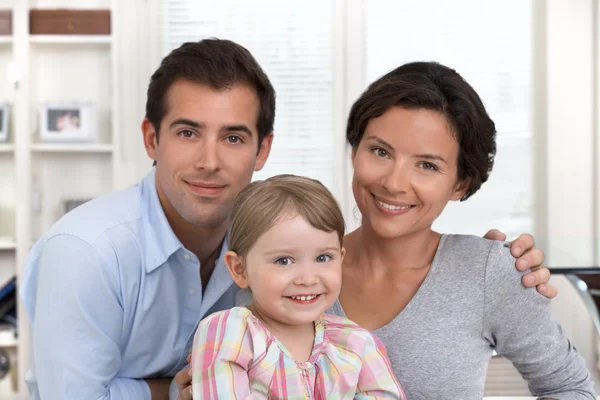 Smiling family portrait sitting in the living room at home — Stock Photo, Image