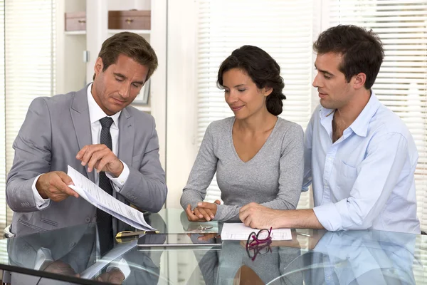 Financial consultant presents bank investments to a young couple — Stock Photo, Image