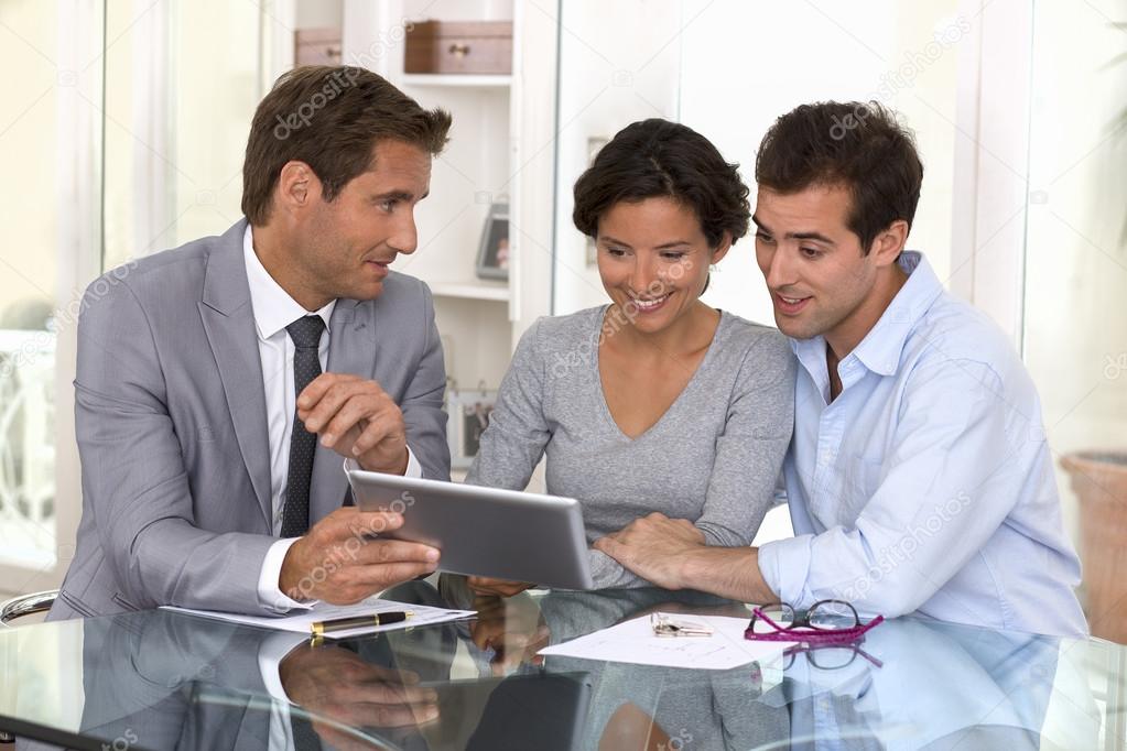 architecte presenting a new project to a smiling young couple