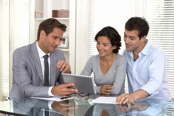 Architecte presenting a new project to a smiling young couple — Stock Photo, Image