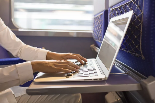 Närbild kvinna händer att skriva på en laptop tangentbord i tåget — Stockfoto