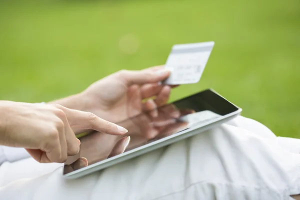 Närbild kvinnas händer håller ett kreditkort och använder tablet pc — Stockfoto