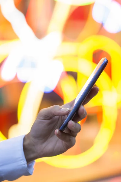 Mobile phone in a woman's hand, colors graphic backgroun — Stock Photo, Image