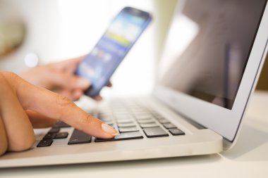 Kadın el ile akıllı telefon ve bilgisayar klavye