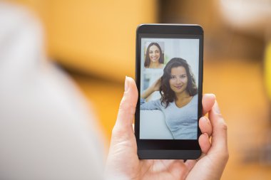 bir akıllı telefon sırasında skype vid tutan bir el closeup