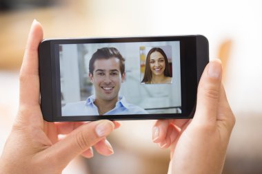 bir akıllı telefon sırasında skype vid tutan bir el closeup