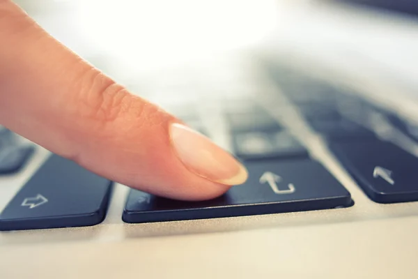 Kvinnlig hand med hjälp av datorns tangentbord, enter-knappen — Stockfoto