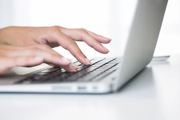 Kvinnliga händer skriva på en bärbar dator tangentbord — Stockfoto