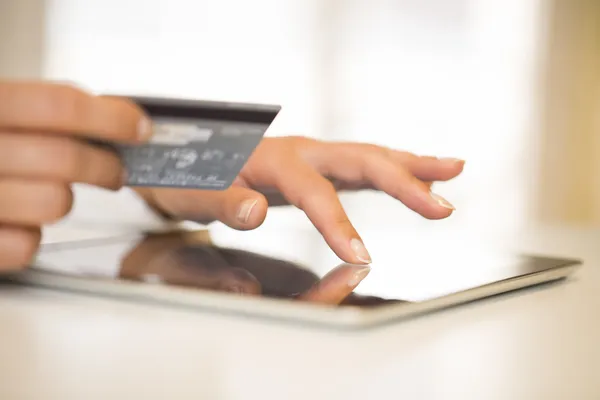 Primo piano mani di donna in possesso di una carta di credito e utilizzando tablet pc — Foto Stock