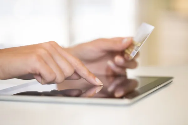 Nahaufnahme der Hände einer Frau, die eine Kreditkarte hält und einen Tablet-PC benutzt — Stockfoto