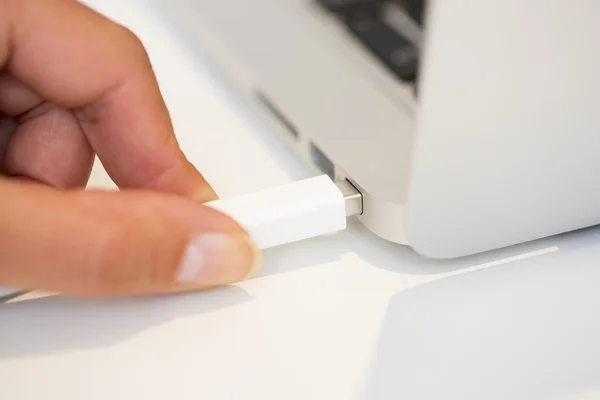 Woman hand Inserting Thunderbolt cable on computer — Stock Photo, Image