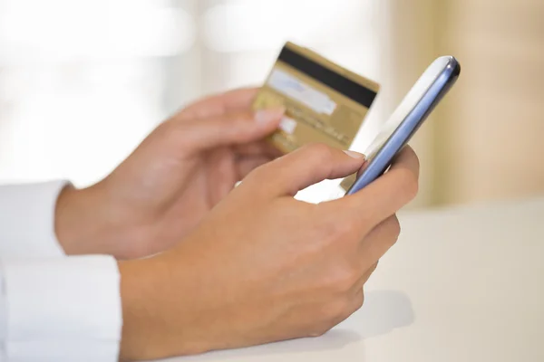 Close-up woman's hands holding a credit card and using cell phon — Stock Photo, Image