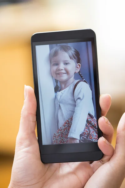 Mano de mujer con smartphone mostrando foto de niño — Foto de Stock